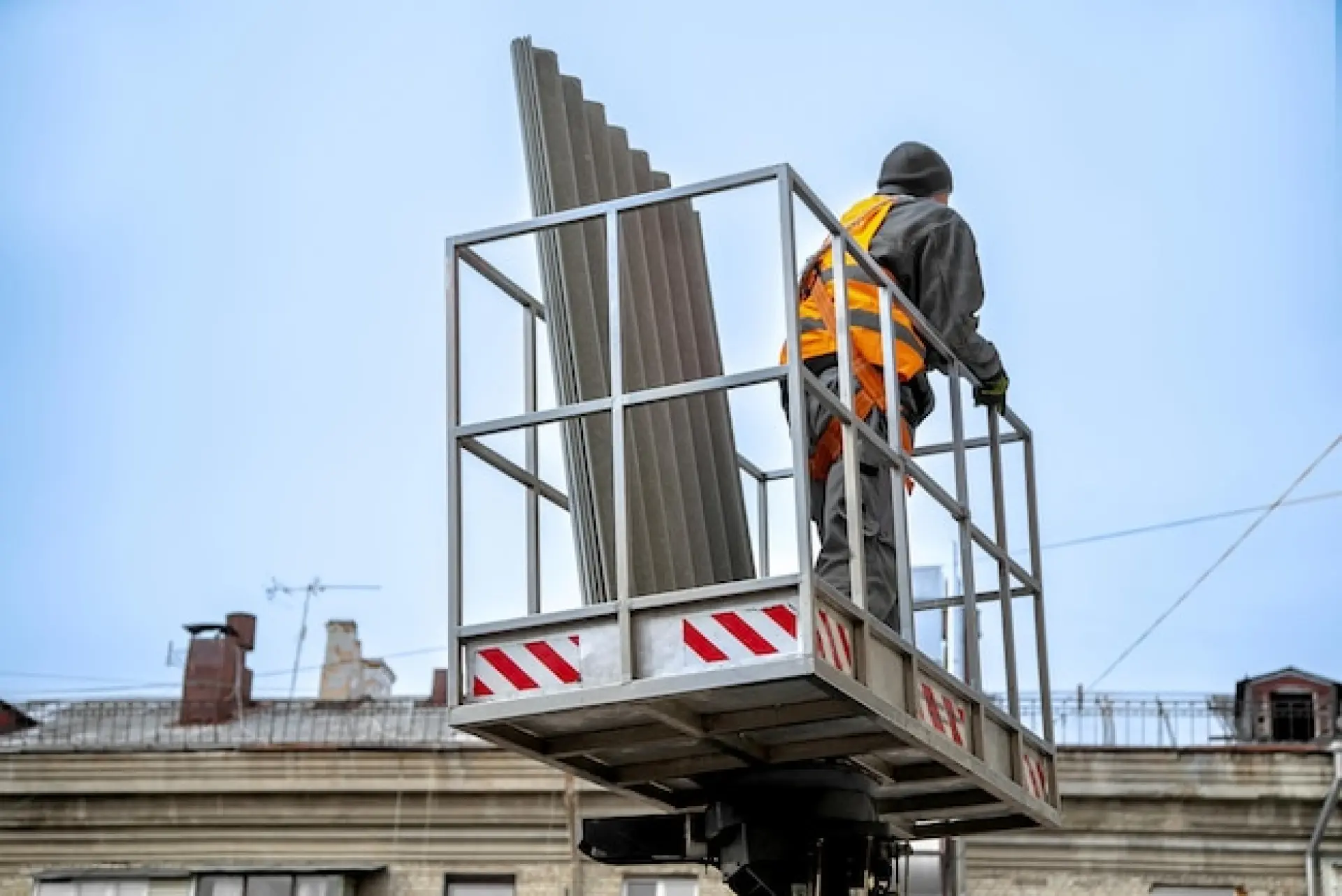 Worker using roof access equipment during edge protection installation